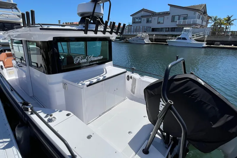 Slide: The Image of 2022 Axopar Brabus 28 Cabin boat docked in a marina, showcasing sleek design and modern features. - 18