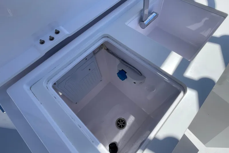 Slide: The Image of 2022 Axopar Brabus 28 Cabin sink and storage compartment detail. - 23