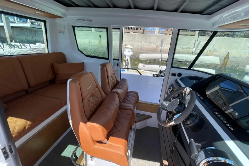 Slide: The Image of Interior of 2022 Axopar Brabus 28 Cabin with luxurious brown seating and modern dashboard. - 33