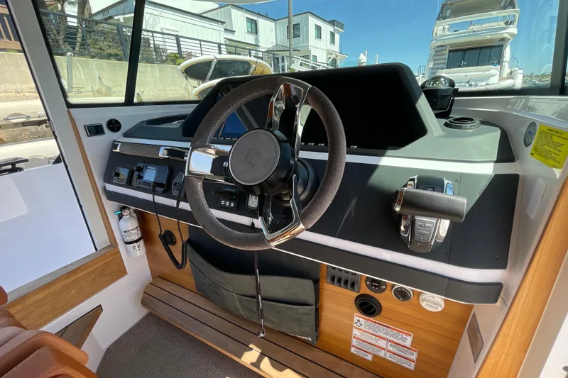 Slide: The Image of Interior view of 2022 Axopar Brabus 28 Cabin boat's steering console and controls. - 34