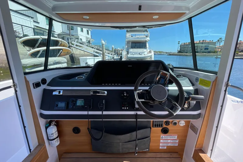 Slide: The Image of 2022 Axopar Brabus 28 Cabin helm with modern controls and waterfront view. - 35