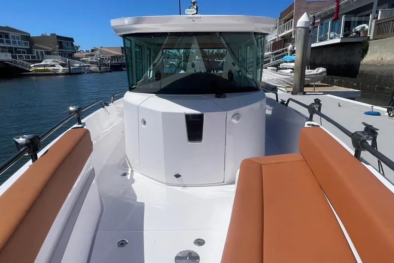 Slide: The Image of 2022 Axopar Brabus 28 Cabin boat with sleek design and comfortable seating in a marina. - 4