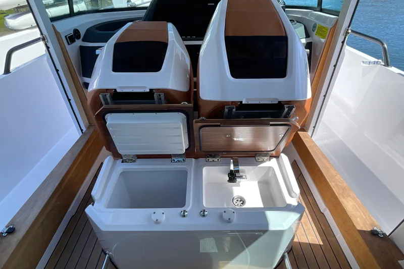 Slide: The Image of 2022 Axopar Brabus 28 Cabin interior with open storage and sink. - 48