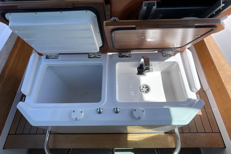 Slide: The Image of 2022 Axopar Brabus 28 Cabin boat sink and storage compartment, open view. - 49