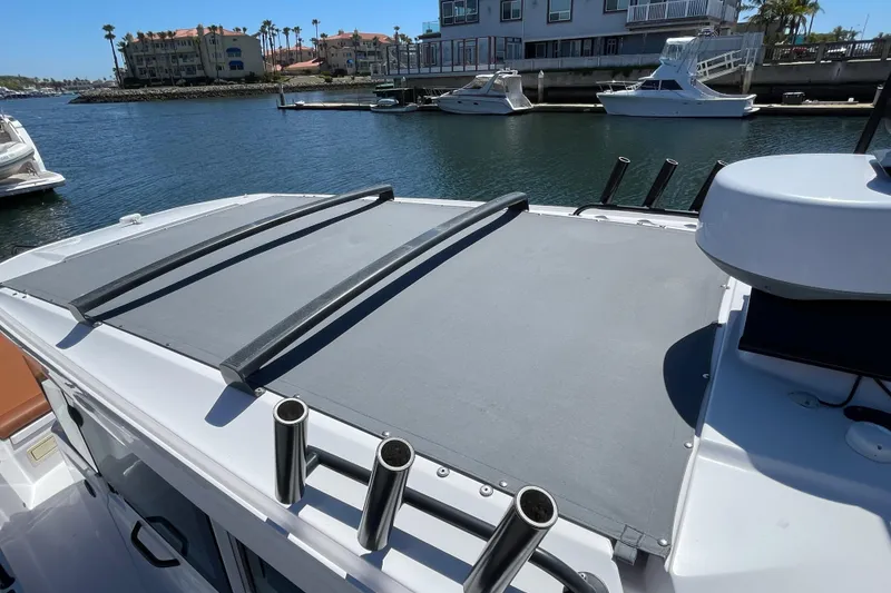 Slide: The Image of 2022 Axopar Brabus 28 Cabin boat docked in a marina, showcasing sleek roof design. - 57