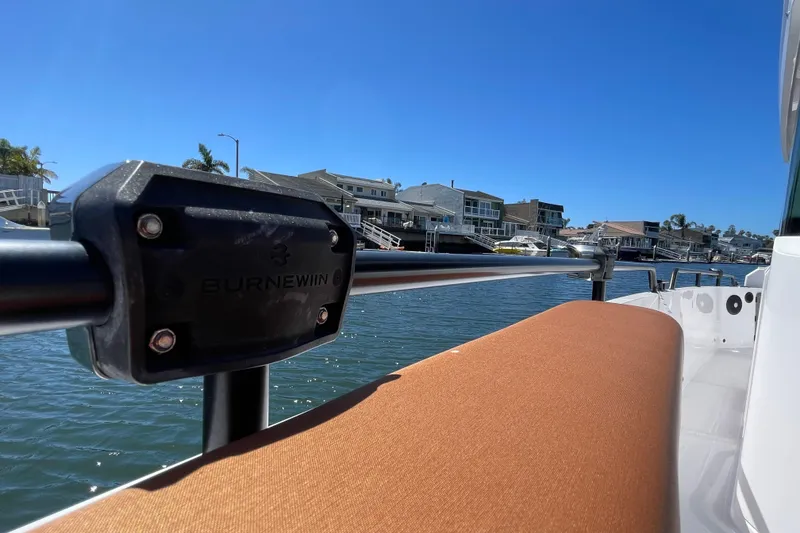 Slide: The Image of 2022 Axopar Brabus 28 Cabin boat with Burnewiin mount, docked by waterfront homes. - 8