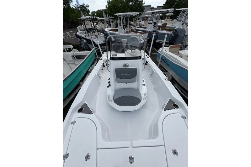 Slide: The Image of 2026 NauticStar 194 Bay boat, sleek white design, parked among other boats. - 12