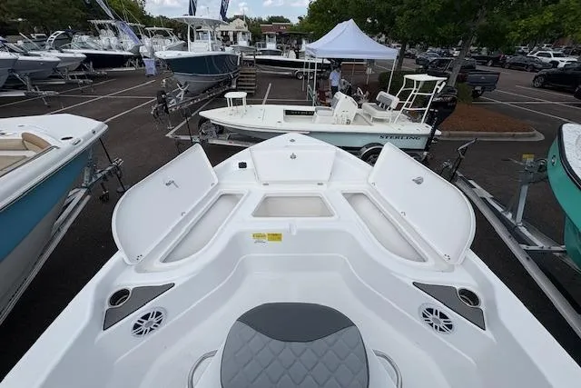 Slide: The Image of 2026 NauticStar 194 Bay boat on display at a marina with open storage compartments. - 14