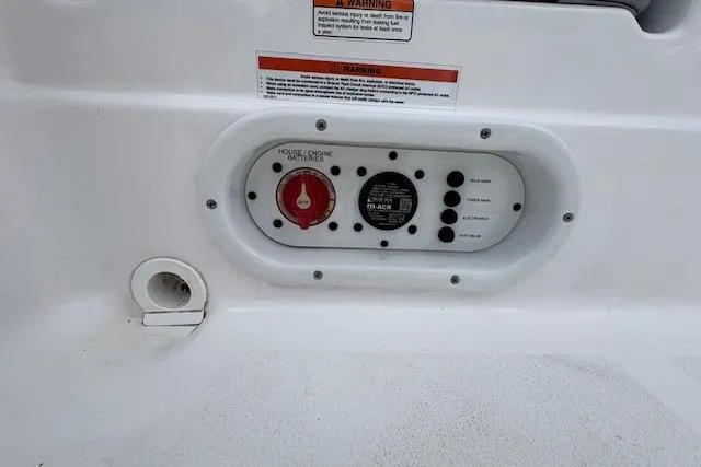 Slide: The Image of Control panel on a 2026 NauticStar 194 Bay boat, featuring switches and warning labels. - 16