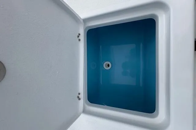Slide: The Image of Open storage compartment on 2026 NauticStar 194 Bay boat, featuring a blue interior. - 17