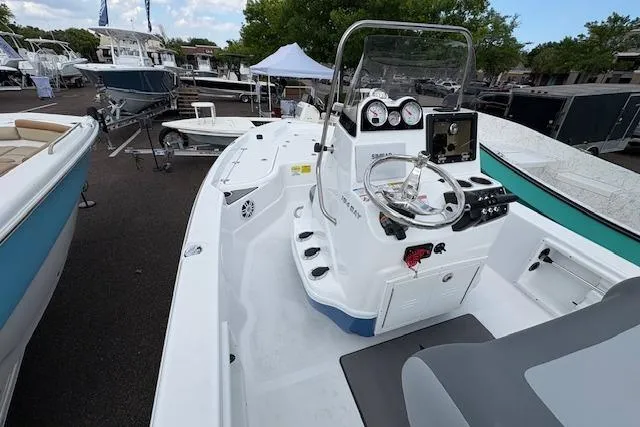 Slide: The Image of 2026 NauticStar 194 Bay boat interior with steering console and seating, displayed outdoors. - 9