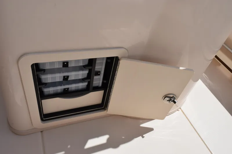 Slide: The Image of 2024 Grady-White Fisherman 236 boat storage compartment with open door and trays. - 20