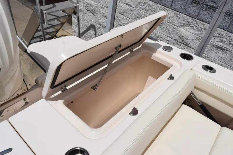 Slide: The Image of 2024 Grady-White Fisherman 236 boat storage compartment with open lid and cup holders. - 23