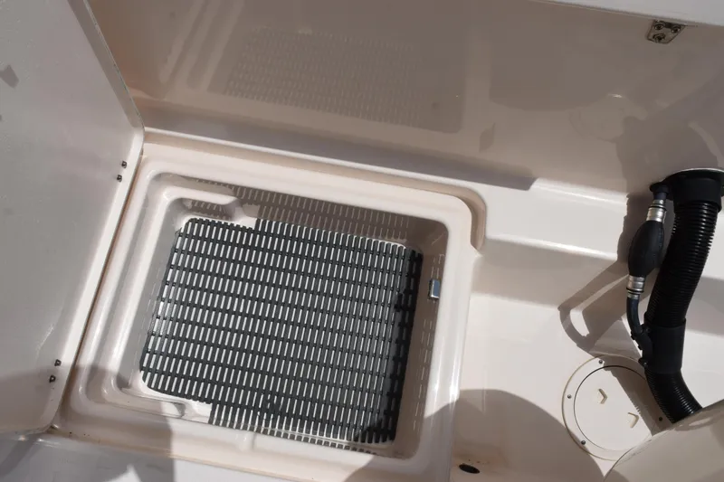 Slide: The Image of 2024 Grady-White Fisherman 236 boat deck with storage compartment and hose. - 25