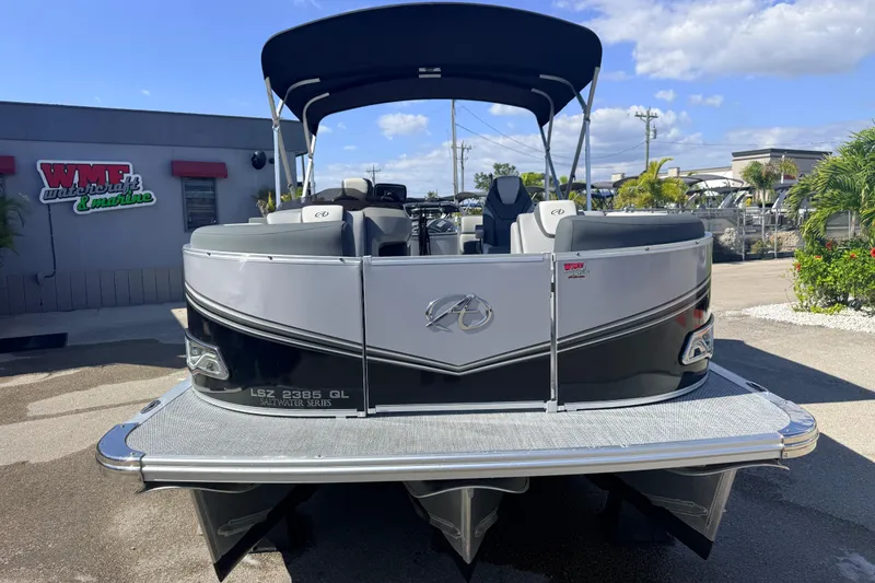 Slide: The Image of 2026 Avalon 2485 LSZ Quad Lounger Tri Toon boat at dealership, sunny day. - 2