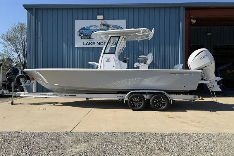 The Image of 2026 Sportsman Masters 247OE Bay Boat on trailer, parked outside a marine facility. - 1