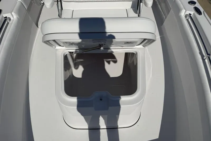 Slide: The Image of Open storage compartment on 2026 Sportsman Masters 247OE Bay Boat, with shadow reflection. - 16