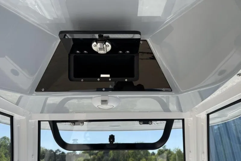 Slide: The Image of 2026 Sportsman Masters 247OE Bay Boat interior with storage compartment and window view. - 17