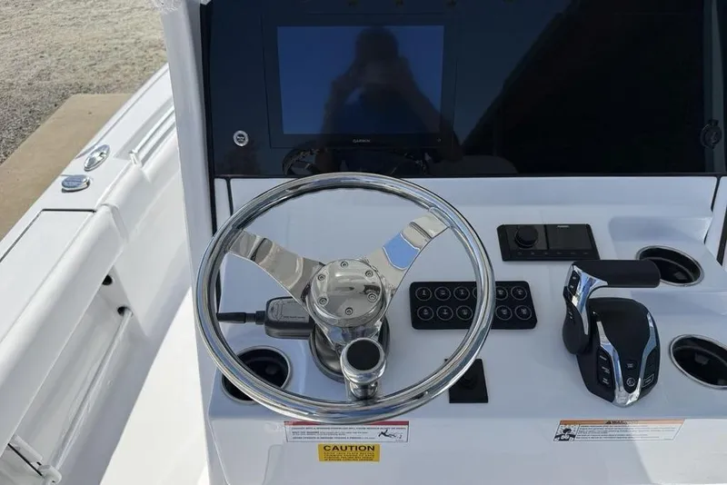 Slide: The Image of Steering console of 2026 Sportsman Masters 247OE Bay Boat with modern controls and display. - 32