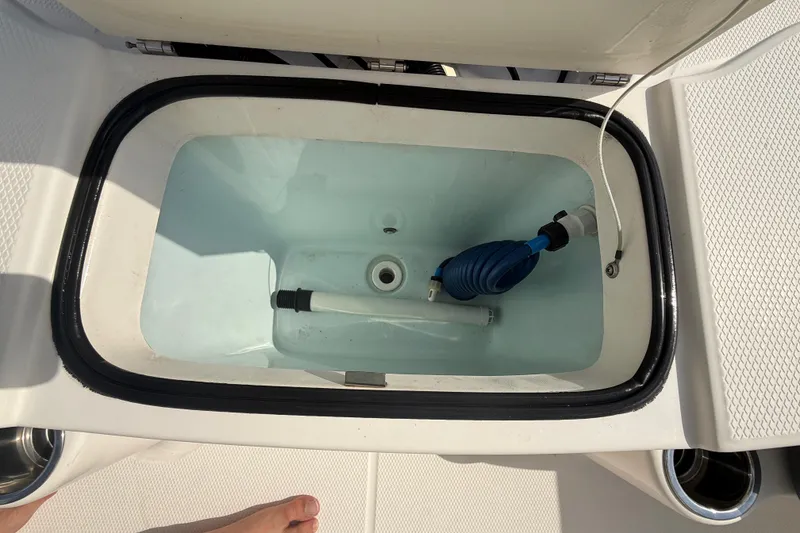 Slide: The Image of Livewell on 2021 Robalo R180 Center Console boat, featuring a clean interior and hose attachment. - 10