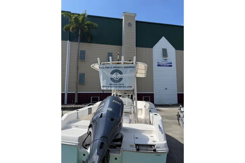 Slide: The Image of 2021 Robalo R180 Center Console boat with Yamaha engine, parked outside a building. - 26