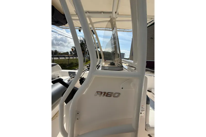 Slide: The Image of 2021 Robalo R180 Center Console boat with clear windshield and console details. - 28