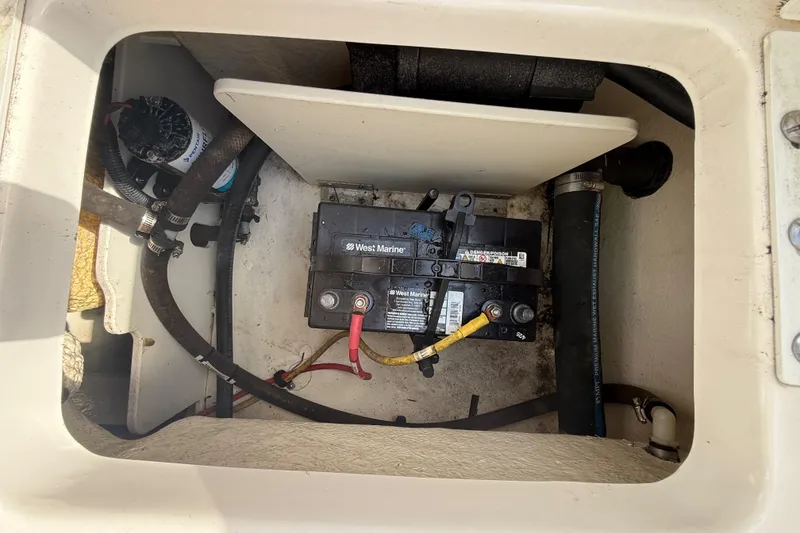Slide: The Image of Battery compartment of a 2021 Robalo R180 Center Console boat, featuring West Marine battery. - 29
