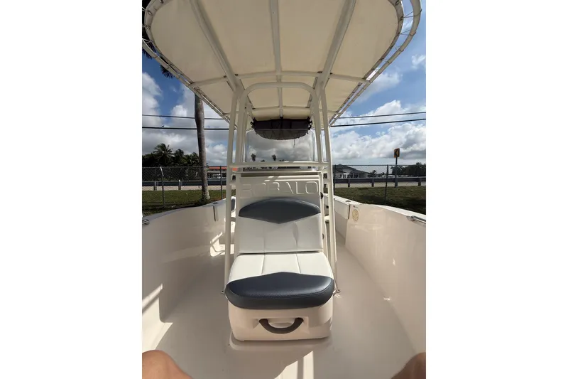 Slide: The Image of 2021 Robalo R180 Center Console boat interior with seating and canopy. - 6