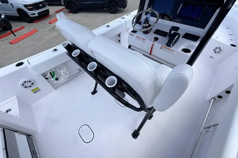 Slide: The Image of 2025 Sportsman Open 232 Center Console boat interior with white seating and steering console. - 14
