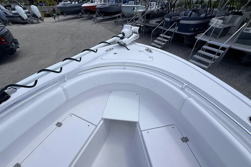 Slide: The Image of 2025 Sportsman Open 232 Center Console boat, white interior, parked among other boats. - 6