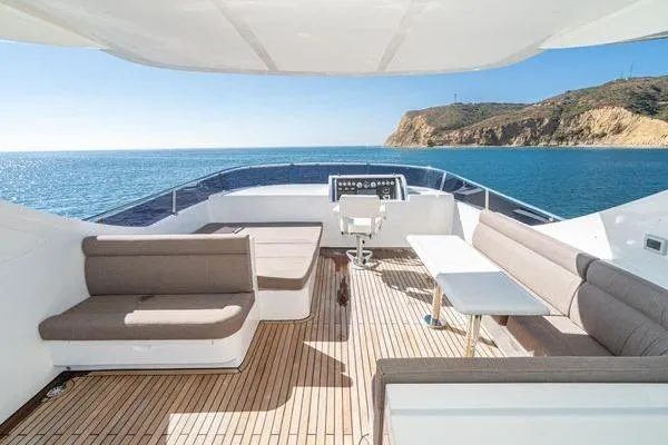 Slide: The Image of Luxurious 2023 Massimo Marine Sunbird yacht deck with seating, ocean view, and coastal backdrop. - 15