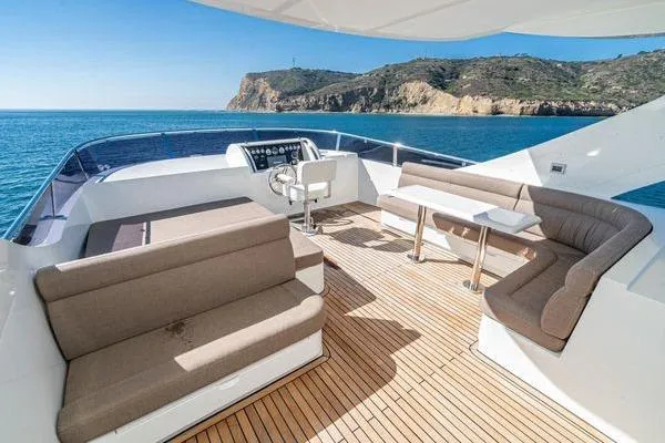 Slide: The Image of Luxurious 2023 Massimo Marine Sunbird yacht deck with seating, overlooking scenic coastal cliffs. - 16