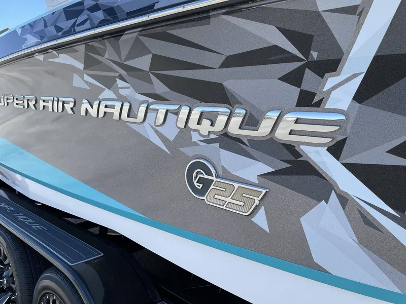 Slide: The Image of 2015 Nautique G25 boat with sleek design and logo. - 16