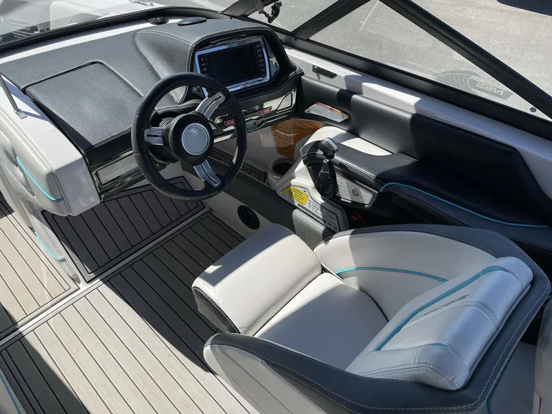 Slide: The Image of Interior of a 2015 Nautique G25 boat with modern steering and seating. - 17