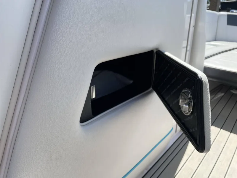 Slide: The Image of 2015 Nautique G25 boat, open storage compartment on deck. - 18
