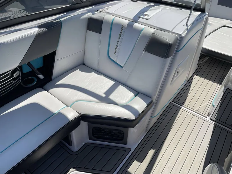 Slide: The Image of Interior of a 2015 Nautique G25 boat with white leather seating. - 20