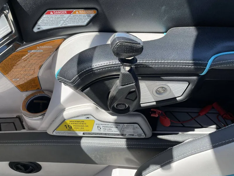 Slide: The Image of Interior of a 2015 Nautique G25 boat with throttle lever and warning labels. - 27