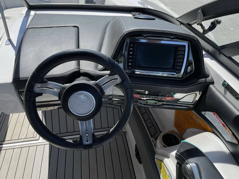 Slide: The Image of Interior view of 2015 Nautique G25 helm with steering wheel and display. - 28
