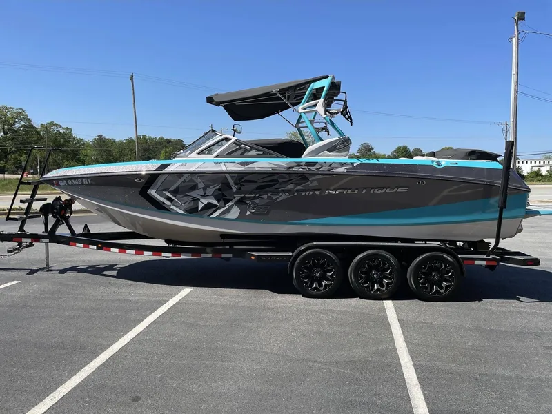 Slide: The Image of 2015 Nautique G25 boat parked on trailer outdoors. - 5