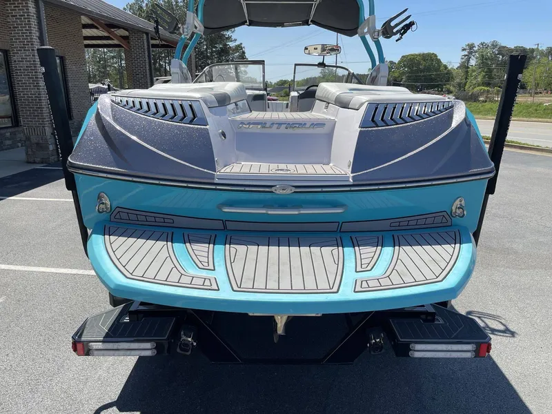 Slide: The Image of Rear view of a blue 2015 Nautique G25 boat in a parking lot. - 7
