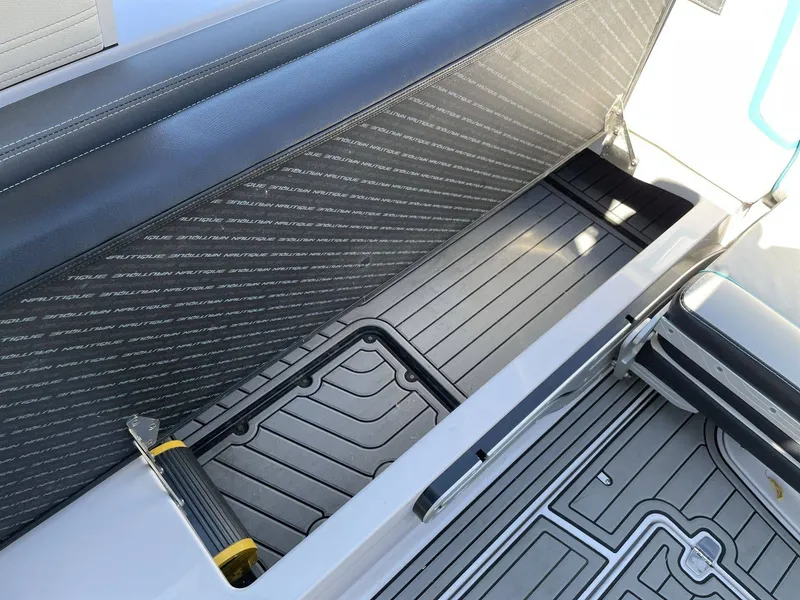 Slide: The Image of Interior of a 2015 Nautique G25 boat with seating and storage area. - 8