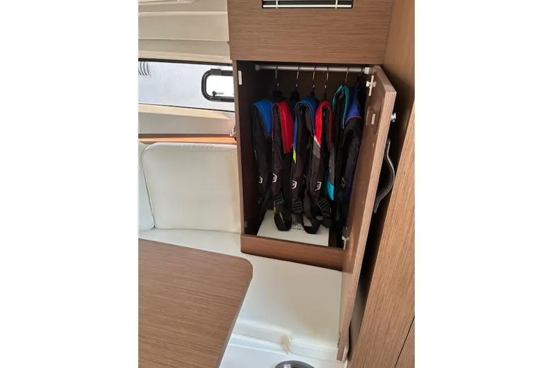 Slide: The Image of 2022 Jeanneau Leader 10.5 WA Series 2 interior with life jackets in wooden cabinet. - 18