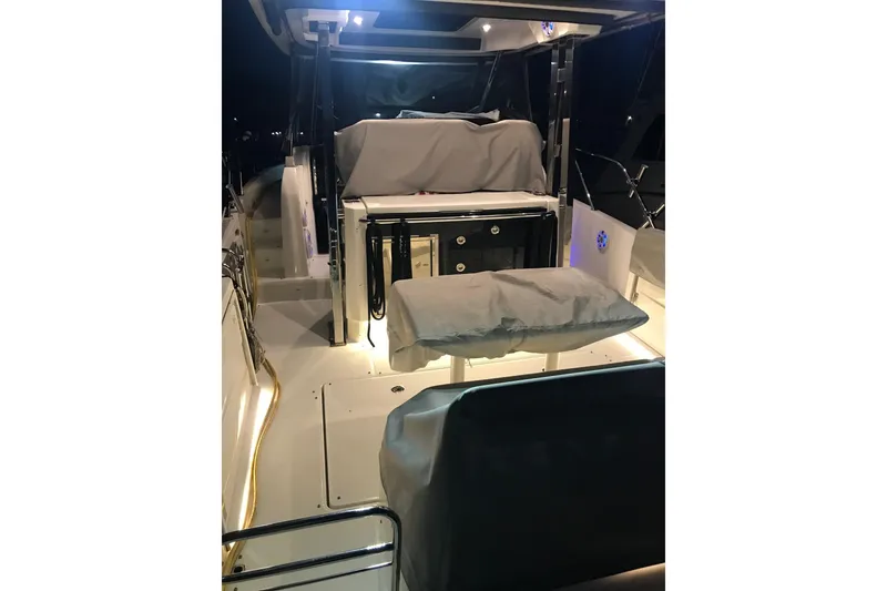 Slide: The Image of 2022 Jeanneau Leader 10.5 WA Series 2 boat interior with covered seating and ambient lighting. - 24