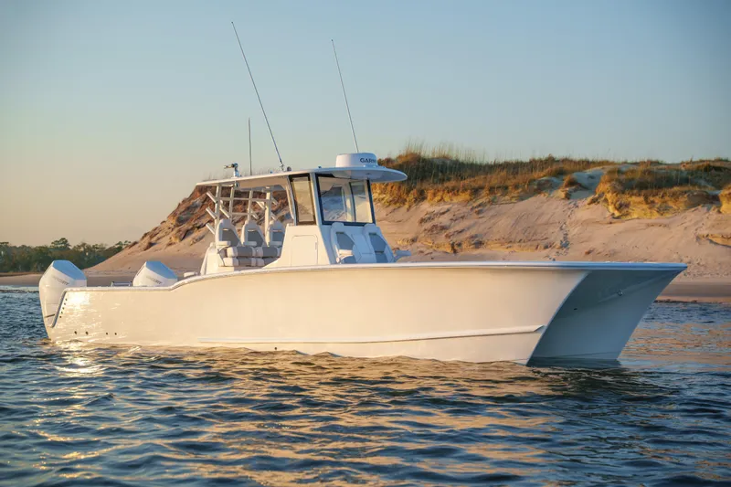 The Image of 2026 Tideline 365 Offshore boat cruising near sandy shoreline at sunset. - 0