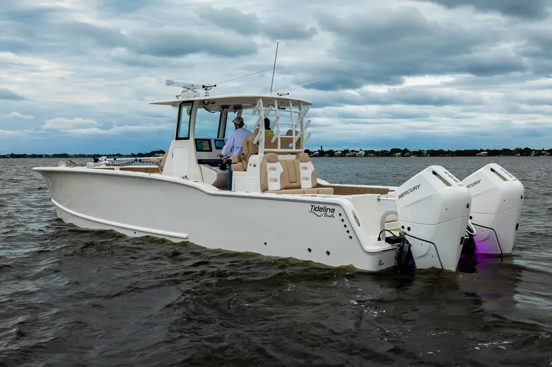 Slide: The Image of 2026 Tideline 365 Offshore boat cruising on a cloudy day with dual Mercury engines. - 10