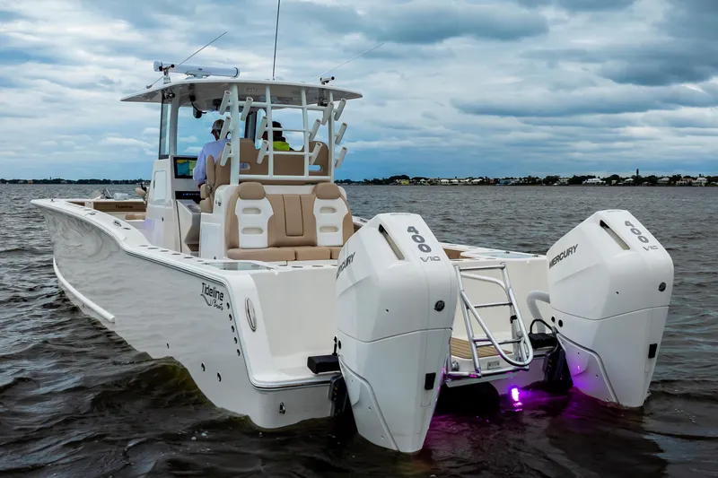 Slide: The Image of 2026 Tideline 365 Offshore boat with dual Mercury engines on a calm water backdrop. - 13