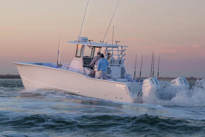 Slide: The Image of 2026 Tideline 365 Offshore boat cruising at sunset with fishing rods and dual engines. - 20