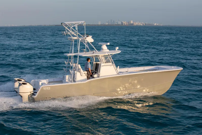 Slide: The Image of 2026 Tideline 365 Offshore boat cruising on open water with city skyline in background. - 33