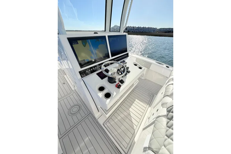 Slide: The Image of 2026 Tideline 365 Offshore boat cockpit with dual screens and steering wheel on water. - 53