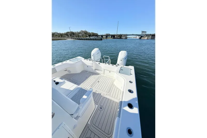 Slide: The Image of 2026 Tideline 365 Offshore boat with dual engines on calm water near a bridge. - 59